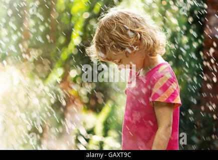 Foto von glückliche kleine Mädchen stehen unter Sommerregen Stockfoto