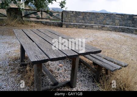 Eine Bank in einem Garten im Schatten eines Baumes. Stockfoto