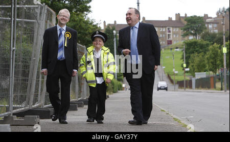 Schottlands erster Minister Alex Salmond, rechts, mit dem zehnjährigen Cameron Fraser, Mitte und Cllr John Mason, links, der nach dem Start des Nachwahlkampfs der SNP Glasgow East am Wellhouse Crescent in Glasgow entlang geht. Stockfoto