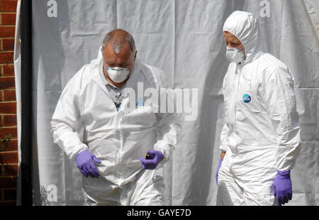 Zwei Arbeiter vor einer Wohnung in Stirling Gardens, New Cross, London, wo am Sonntag zwei französische Studenten festgebunden, gefoltert und getötet wurden. Stockfoto