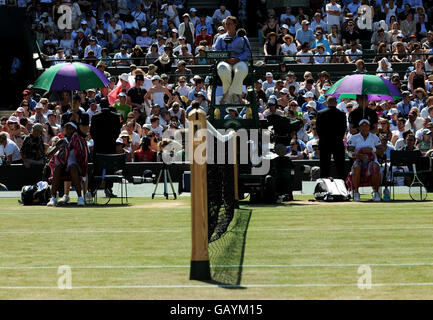 Die USA Venus Williams (links) und Thailands Tamarine Tanasugarn schatten in ihrer Pause während der Wimbledon Championships 2008 im All England Tennis Club in Wimbledon vor der Sonne. Stockfoto