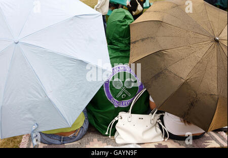 Tennis-Fans schützen sich vor dem Regen auf Murray Mount während der Wimbledon Championships 2008 im All England Tennis Club in Wimbledon. Stockfoto