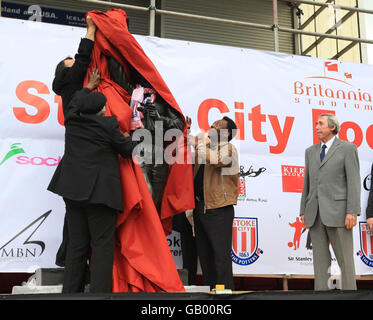 Pele und Erzbischof Desmond Tutu enthüllen die Statue von Gordon Banks, während der England-WM-Gewinner vor dem Charity-Spiel Gordon Banks XI gegen Pele XI im Britannia Stadium von Stoke City aufschaut. Stockfoto