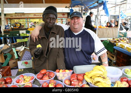 Neil Stockwell, zweite Generation Standbesitzer in Queens Markt, Newham, East London und Assistent Alagi Nyang posieren für Fotos. Stockfoto