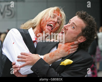 Der Schauspieler Alan M Crawford wird bei der Premiere von Nordirlands erstem Zombie-Horrorfilm „The Battle of the Bone“ in der Odyssey Arena, Belfast, von Zombie Johnny Burmside angegriffen. Stockfoto