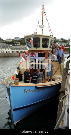 Der Prinz von Wales (vierte links) und die Herzogin von Cornwall (fünfte links) steigen vor der offiziellen Enthüllungszeremonie in St. Mawes, Cornwall, an Bord der Fähre St. Mawes nach Falmouth, die die Herzogin von Cornwall heißt. Stockfoto