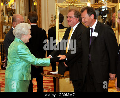 Königin Elizabeth II schüttelt Sir Gus O'Donnell die Hände, als sie bei einer Zeremonie im Buckingham Palace in London einen Empfang für die Gewinner des Queen's Award for Enterprise veranstaltet. Stockfoto