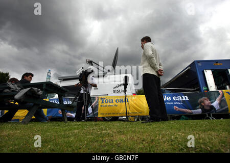 SIS van im Broadcast-Gelände bei den GB-olympischen Leichtathletik-Prüfungen in Birmingham. Das blaue Fahrzeug rechts ist SIS (ehemals BBC Outside Broadcast Vehicles). Stockfoto