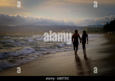 Silhouette von Mann und Frau Wlaking hand an einem Strand an der Riviera Nayarit, Mexiko Stockfoto