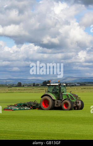 Ein landwirtschaftlicher Rasenmäher in Burscough, Lancashire, Großbritannien, fährt mit einem Fendt 514 Vario-Traktor, der eine neue Grasernte, Grün, Gras, Natur, Rasen mäht, wachsen, Pflanzen, wachsen, Feld, Hintergrund, Wiese, Frühling, Natur, Sommer, Garten, Umwelt, angebaut für die lokale Nachfrage nach Rasen. Auf diesen Feldern wird dieses Jahr Gras angebaut, das Teil des Fruchtwechselsystems der Landwirte ist. Das Prinzip der Fruchtfolge besteht darin, jedes Jahr bestimmte Gruppen von Gemüse in verschiedenen Teilen des Betriebs anzubauen. Stockfoto