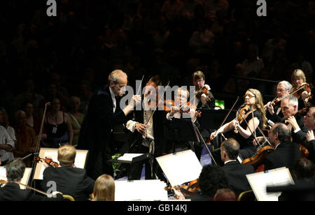 Nigel Kennedy (Mitte, stehend) tritt mit dem BBC Concert Orchestra, Dirigent Paul Daniel (links, stehend), während des Prom 2-Konzerts bei den BBC Proms in der Royal Albert Hall in London auf. Stockfoto