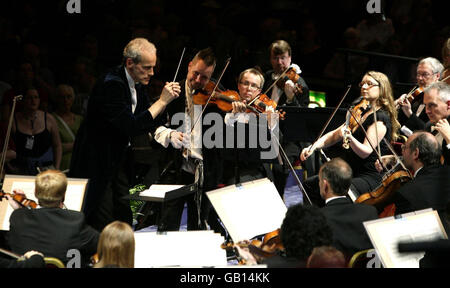 Nigel Kennedy (Mitte, stehend) tritt mit dem BBC Concert Orchestra, Dirigent Paul Daniel (links, stehend), während des Prom 2-Konzerts bei den BBC Proms in der Royal Albert Hall in London auf. Stockfoto