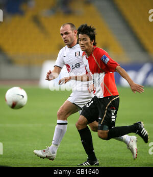 Fulhams Danny Murphy (l.) und Busan Icons' Kang Seung Jo Kampf um den Ball Stockfoto