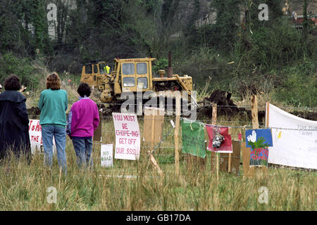 Demonstranten von Friends of the Earth beobachten, wie die Bulldozer sich auf die Wasserwiesen auf Twyford Down in Hampshire bewegen, während sie den Weg für die M3 Motorway Extension vorbereiten. Stockfoto