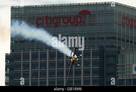 Der US-Amerikaner Kirby Chambliss fliegt vor dem Citigroup-Gebäude in Canary Wharf, als er am Qualifying für die Londoner Etappe der Red Bull Air Race World Series über der Themse teilnimmt. Stockfoto