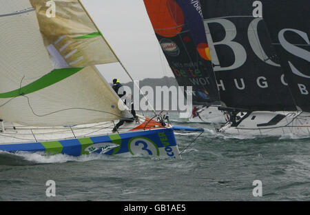 Die Crew an Bord von Mike Golding's Ecoverwechseln die Segel (links), während die Flotte der Hightech Open 60 Yachten sich während der Artemis Challenge um das Inselrennen in der Skandia Cowes Week den Needles nähert. Sie konkurrierten um 10,000 zu gewinnen, um ihre gewählte Nächstenliebe zu geben. Zu den Berühmtheiten, die an Bord der Yachten gefahren sind, gehören Big Brother-Moderatorin Davina McCall, der ehemalige olympische Zehnkämpfer Dean Macey, TV-Moderator Johnny Ball, England-Rugby-Spieler James Haskell und Alastair Campbell. Stockfoto