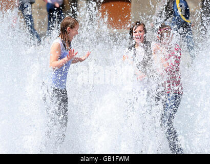 Junge Leute kühlen sich im Brunnen in Middlesbrough ab, während das Vereinigte Königreich warmes Sommerwetter erlebt. Stockfoto