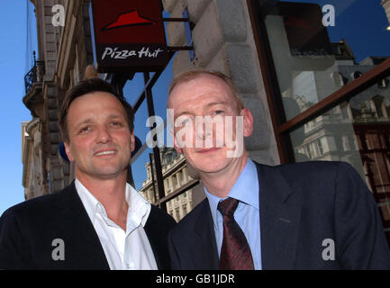 Alasdair Murdoch, Chief Executive von Pizza Hut bei Pat McFadden, Minister für Arbeitsbeziehungen (rechts) vor Pizza Hut in der Regent Street, London. Kundentipps in Bars und Restaurants werden nicht mehr auf die Bezahlung der Mitarbeiter angerechnet, um sie auf den Mindestlohn zu bringen, teilte die Regierung heute mit. Stockfoto