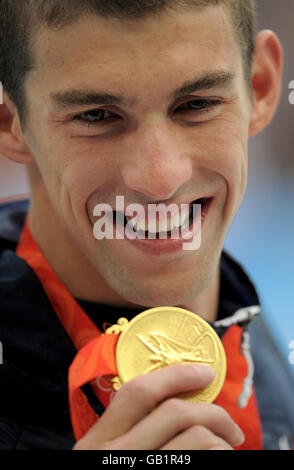 Der US-Amerikaner Michael Phelps zeigt seine Goldmedaille, die er bei den Olympischen Spielen 2008 in Peking im National Aquatics Center in der 200 Meter Freistil gewonnen hat. Stockfoto