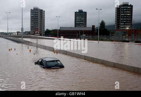 Ein Autofahrer wird bei den schweren Überschwemmungen im Westlink-Gebiet von Belfast, Nordirland, gefangen. Stockfoto