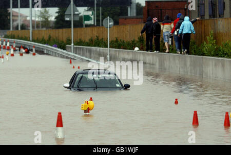 Ein Auto eines Autofahrers wird nach schweren Überschwemmungen in der Region Westlink in Belfast, Nordirland, aufgegeben. Stockfoto