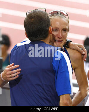 Die britische Paula Radcliffe wird von ihrem Mann Gary Lough nach dem Frauen-Marathon im Nationalstadion während der Olympischen Spiele 2008 in Peking, China, getröstet. Stockfoto