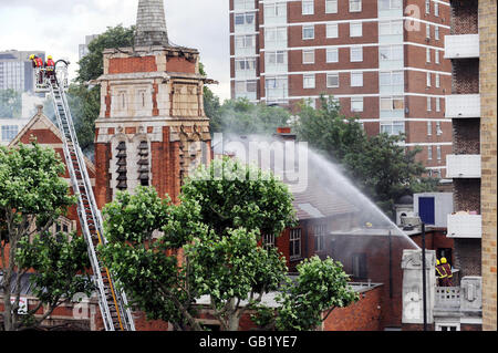 Feuer in der Kirche in London. Feuerwehrleute greifen die Überreste eines Feuers auf das Ministerium der Großen Kommission, Shepherd's Bush, London, an. Stockfoto