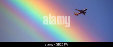 Ein Flugzeug von British Airways fliegt über einen Regenbogen, während es bei wechselhaften Wetterbedingungen in Richtung Heathrow in London geht. Stockfoto