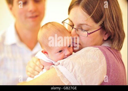 Rebecca und Ian Bloomer halten das neugeborene Mädchen Evie in der IVF-Klinik am University Hospital of Wales, Cardiff, in der Hand, das mit dem neuen IVF-Vitrifikationsprozess 7 Pfund 10 Unzen wog. Stockfoto