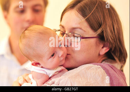 Rebecca und Ian Bloomer halten das neugeborene Mädchen Evie in der IVF-Klinik am University Hospital of Wales, Cardiff, in der Hand, das mit dem neuen IVF-Vitrifikationsprozess 7 Pfund 10 Unzen wog. Stockfoto