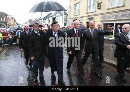 (Mitte von links nach rechts) Taoiseach Brian Cowen mit dem stellvertretenden Ersten Minister Martin McGuinness und anderen Delegierten am Standort der Omagh-Bombe von 1998. Stockfoto