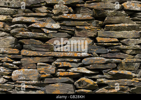 Wand, bestehend aus verschiedenen Stücken aus Basalt mit Flechten bedeckt Stockfoto