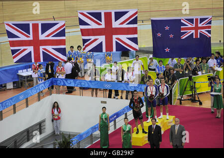 Die Briten Bradley Wiggins und Steven Burke feiern ihre jeweiligen Gold- und Bronzemedaillen bei der individuellen Männerjagd mit dem Neuseeländer Hayden Roulston in Silber auf dem Track Cycling Course auf dem Laoshan Velodrome während der Olympischen Spiele 2008 in Peking in China. Stockfoto