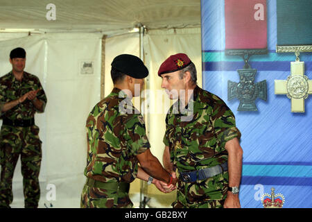 Lance Corporal Agnish Thapa von den Royal Gurkha Gewehren erhält Glückwünsche von LT General Graeme Lamb zu seiner Verleihung eines Militärkreuzes für seine Verdienste in Afghanistan in Victoria Barracks in Windsor, Berkshire. Lance Corporal Thapa schleppte einen tödlich verwundeten Soldaten 100m unter intensivem Feuer. Stockfoto