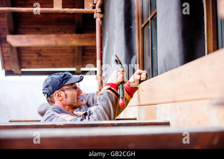 Bau Arbeiter thermisch isolierende Haus, machen Holz fac Stockfoto