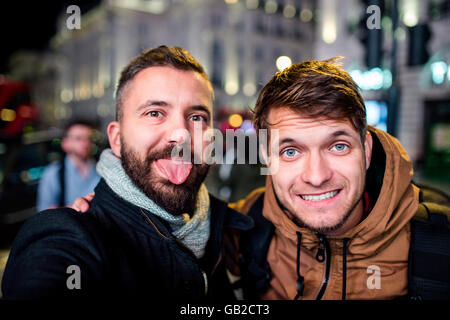 Zwei Männer gehen in den Straßen von London in der Nacht Stockfoto