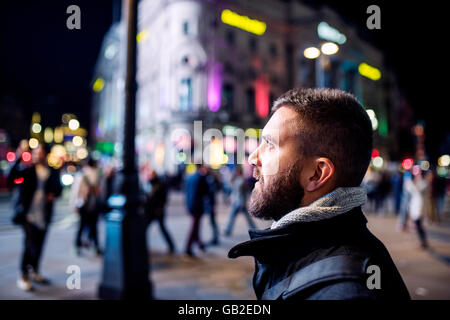 Mann zu Fuß in den Straßen von London in der Nacht Stockfoto