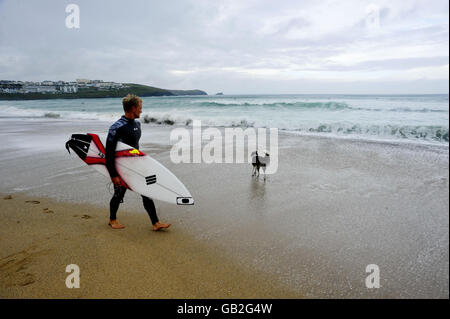 Surfer Adam Melling aus Australien spaziert am Fistral Beach, Newquay, entlang der Küste bei den einwöchigen Rip Curl Boardmasters 2008. Stockfoto