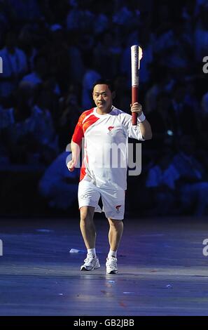 Ein akrobat trägt die olympische Fackel während der letzten Etappe des Fackellaufs während der Eröffnungszeremonie der Olympischen Spiele 2008 in Peking im Nationalstadion in Peking, China. Stockfoto