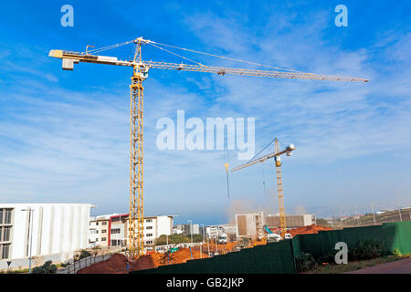 Zwei gelbe hoch heben schwere Krane auf Baustelle gegen blauen Himmel Stockfoto
