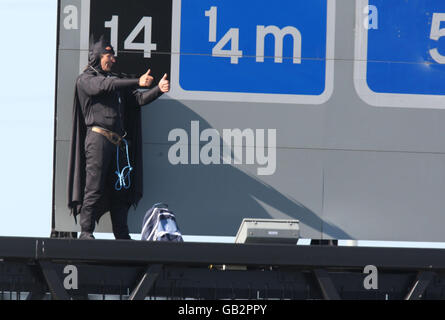 Der Wahlkämpfer Geoffrey Hibbert, vermutlich mit Fathers 4 Justice verbunden, bekleidet als Batman auf einer Gantry über der M25 in der Nähe des Flughafens Heahtrow, London. Stockfoto