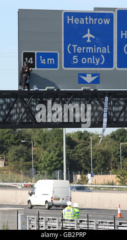 Der Wahlkämpfer Geoffrey Hibbert, vermutlich mit Fathers 4 Justice verbunden, bekleidet als Batman auf einer Gantry über der M25 in der Nähe des Londoner Flughafens Heathrow. Stockfoto