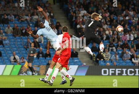 Micah Richards von Manchester City fordert den Torhüter des FC Midtjylland Lasse Heinze während des UEFA-Pokals, der zweiten Qualifikationsrunde, der ersten Etappe im City of Manchester Stadium, Manchester, heraus. Stockfoto