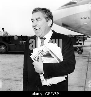 Tony Hancock, der Komiker mit der großen Anhängern von Fans aus allen Gesellschaftsschichten, Er hält sich an einem Stapel Sonntagszeitungen, als er an einem Pan American Clipper antritt, bevor er den Flughafen London Heathrow nach New York verlässt. Er geht nach Amerika, um zu sehen, wie das Fernsehen auf der anderen Seite des Atlantiks funktioniert und lebt. Stockfoto