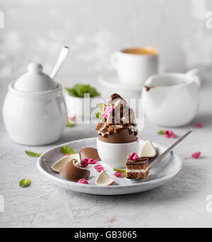 Dreifache Schokoladendessert mit frischer Minze Blätter und Blütenblätter gezuckert Stockfoto