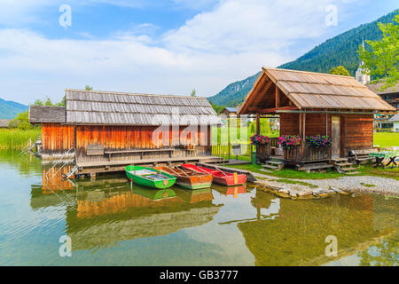 Angelboote/Fischerboote und Holzhäuser am Ufer des Weißensee in Sommerlandschaft Carinthia Land, Österreich Stockfoto