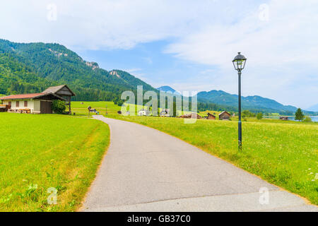 Pfad in kleinen alpinen Dorf am Ufer des Weißensee mit traditionellen Häusern im Hintergrund, Österreich Stockfoto