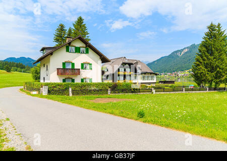 Zu Fuß Seepromenade mit Blick auf typische alpine Berghütten in Sommerlandschaft von Weißensee, Österreich Stockfoto