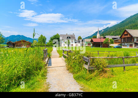 Pfad in kleinen alpinen Dorf am Ufer des Weißensee mit traditionellen Häusern im Hintergrund, Österreich Stockfoto