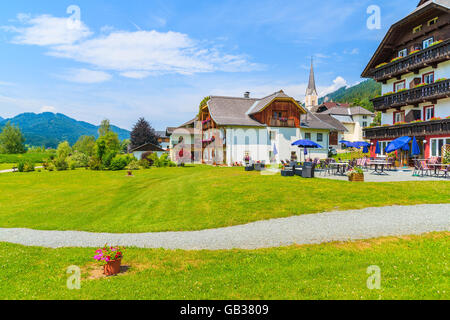 Pfad in kleinen alpinen Dorf am Ufer des Weißensee mit traditionellen Häusern im Hintergrund, Österreich Stockfoto